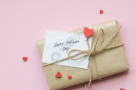 以棕色手工艺纸和领带绳包装在浅粉红色背景上 母亲节礼物盒 顶级风景 女性 可爱的图片