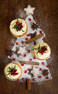 圣诞纸杯蛋糕 上面有香草霜 红莓和木本底迷迭香 装饰品 饼干图片