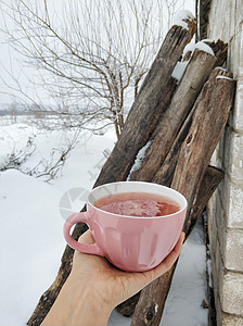 一个粉红杯子 在寒冬雪场背景上加热兰莓茶 寒冷的冬季有果酱和热味茶 自然 爱图片