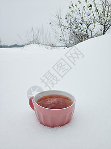 一个粉红杯子 在寒冬雪场背景上加热兰莓茶 寒冷的冬季有果酱和热味茶 饮料 可可图片