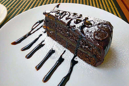一个美丽的美味巧克力蛋糕 一块在白色盘子上 心 甜的图片