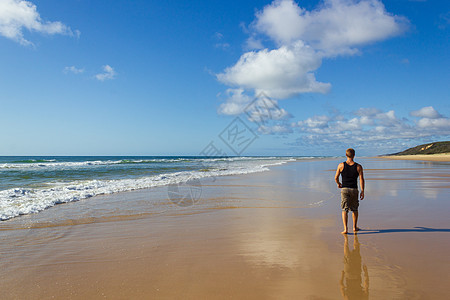 走在弗雷泽岛主要交通公路上的年轻人-面向太平洋的宽阔湿沙滩海岸-长 75 英里的海滩图片