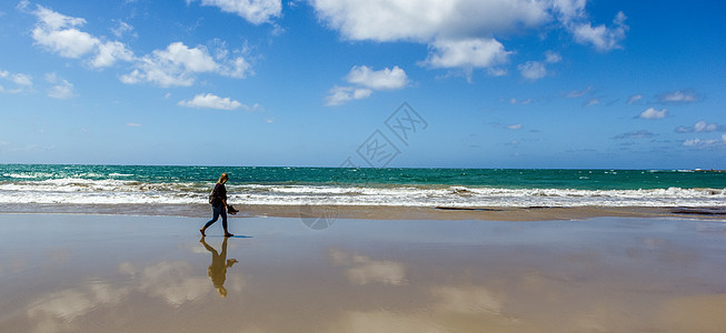 年轻女子在空旷的野生海滩上行走 在大大洋路的水面照着镜子图片