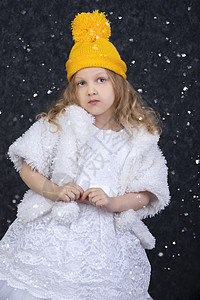 穿着黄编织帽子和优雅白色礼服的小美女孩图片