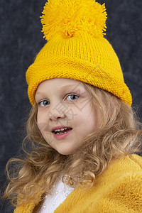 一个漂亮的小女孩 穿着黄毛编织的黄色帽子和温暖的毛皮大衣 冬天 针织图片