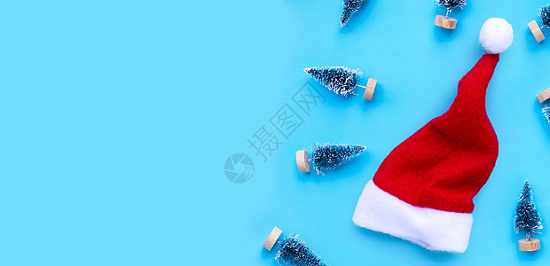 圣诞圣诞帽 蓝色背景的小型圣诞松树 快乐的 季节图片