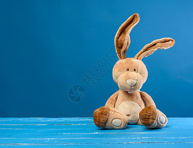 长着大耳朵和蓝底笑脸的花边小兔子 棕色的 毛皮图片