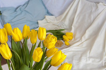 一束新鲜的黄色郁金香特写 床上背景的室内鲜花 早餐包括咖啡和自制果酱 春天的概念和三月的假期 花朵 妇女节图片