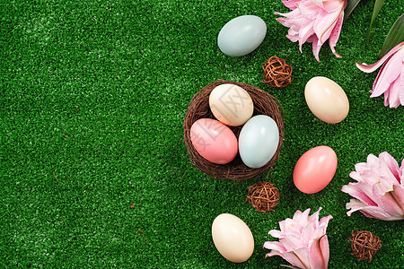 有粉红色双百合百合花的草坪上的巢穴里 藏着多彩的复活节鸡蛋 装饰风格 鸟图片