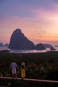 一对中年男女在泰国攀牙湾看日出 攀牙湾观景台 一对夫妇在游泳池边看日出 无边泳池俯瞰泰国攀牙湾 假期 海图片