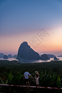 一对中年男女在泰国攀牙湾看日出 攀牙湾观景台 一对夫妇在游泳池边看日出 无边泳池俯瞰泰国攀牙湾 海洋 海景图片
