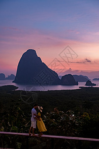 一对中年男女在泰国攀牙湾看日出 攀牙湾观景台 一对夫妇在游泳池边看日出 无边泳池俯瞰泰国攀牙湾 绿松石 蓝色的图片