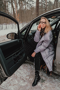 迷人的年轻女性看着车窗外等待旅行和微笑 冬季旅行 坐在车里的女人 圣诞节 执照图片