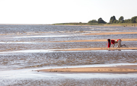 在海滩上穿红泳衣的女孩 青年 假期 太阳 游泳衣 天图片
