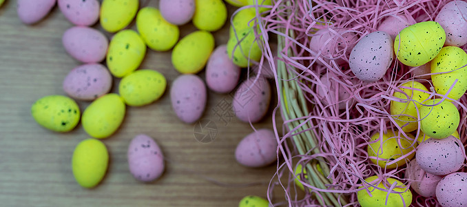 五颜六色的黄色和粉色复活节彩蛋 木桌上有雀斑图案 有复制空间 在篮子里的粉色和黄色复活节彩蛋 快乐的 框架图片
