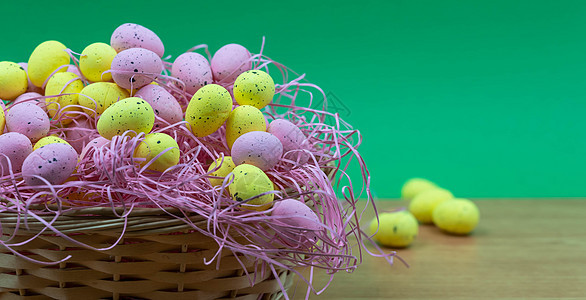 五颜六色的黄色和粉色复活节彩蛋 木桌上有雀斑图案 有复制空间 在篮子里的粉色和黄色复活节彩蛋 午餐 卡片图片