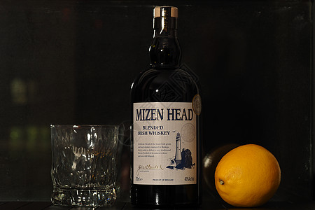 一瓶爱尔兰威士忌和柠檬 在黑色背景上 餐厅图片