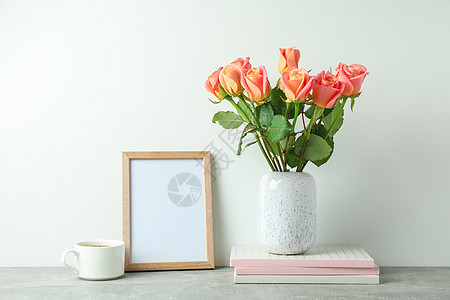 用粉红玫瑰 复印本 空边框 白底面灰色桌上的咖啡杯图片