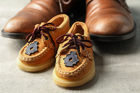 灰色背景空间中的棕色皮鞋和儿童鞋 用于文字和特写 家庭 婴儿图片