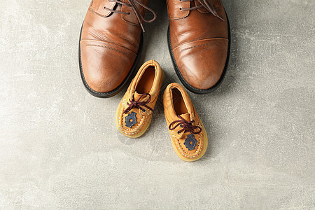 灰色背景空间中的棕色皮鞋和儿童鞋 用于文本和顶部视图 生活 商务人士图片