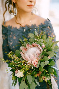 唯美婚纱新娘穿着时装的蓝色礼服 在旧城佩拉斯特 有婚礼花束背景