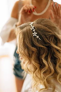 在婚礼筹备期间 发型师在新娘的发型上加了一个发型图片