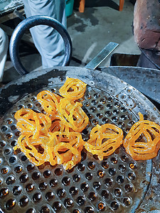 Jalebi是一种著名的印度甜食 这显示了 jalebi 是如何第一次在 oi 中油炸的图片