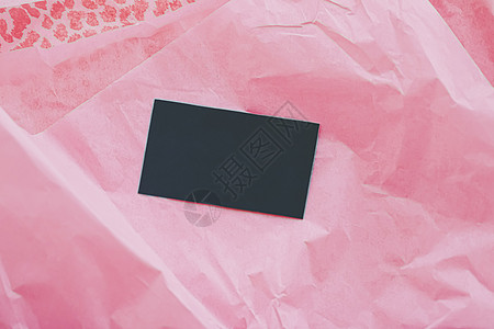 粉色薄纸背景上的黑色名片平铺 奢侈品牌平铺和品牌标识设计模型 宏观 样机图片