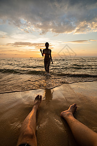 日落时在海滩上挂着男人的双腿 太阳 海浪 女朋友图片