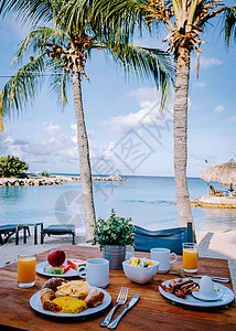 在海滩边的桌子上享用早餐 俯瞰大海 加勒比海 早餐桌上供应咖啡 橙汁 羊角面包和水果 餐厅 果汁图片