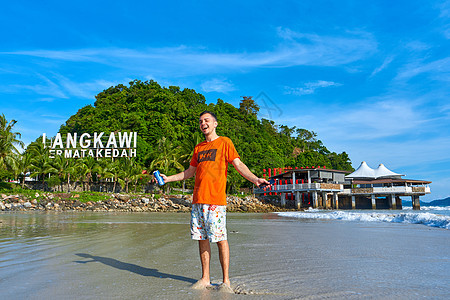 兰卡维热带岛屿中央海滩上快乐的旅游男游客图片