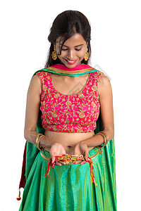 在白色背景下展示Rakhi的美丽女孩 修女将Rakhi领结为强烈爱她哥哥的象征 节日 纽带图片