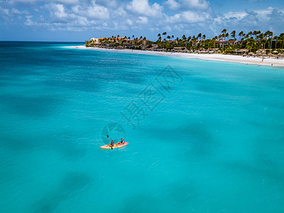 阿鲁巴加勒比海度假时在大洋中发生对夫妇交战 洋蓝水中的男女年中皮艇为男性和女性 女士 娱乐图片