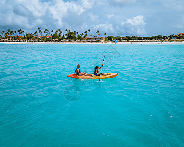 阿鲁巴加勒比海度假时在大洋中发生对夫妇交战 洋蓝水中的男女年中皮艇为男性和女性 团体 热带图片