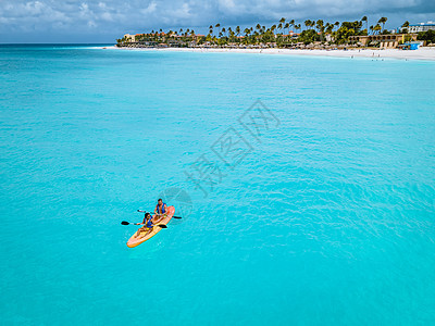 阿鲁巴加勒比海度假时在大洋中发生对夫妇交战 洋蓝水中的男女年中皮艇为男性和女性 冒险 美丽的图片