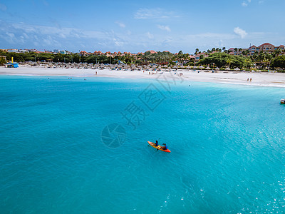 阿鲁巴加勒比海度假时在大洋中发生对夫妇交战 洋蓝水中的男女年中皮艇为男性和女性 支撑 游乐设施图片