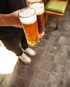 男人并排拿着白啤酒和黑啤酒 乌贼 食物 啤酒杯 盐渍图片