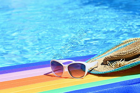 阳光明媚的天气下 太阳镜 李洛和帽子在水面上 夏季旅行和度假背景 假日戏剧 热带 游泳图片