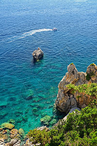 美丽的海滩和小船 有海湾的干净的海 旅行 度假和旅游的概念 暑假和游泳的好地方 科孚岛 希腊 石头 波浪图片