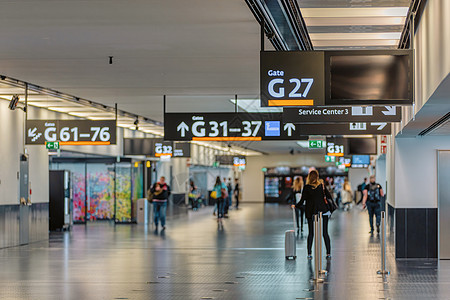 在维也纳机场终点站行走的人 车站 包 假期 运输图片