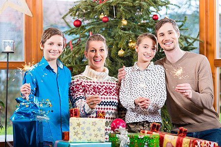 父母和孩子的家庭 在圣诞树下带礼物的妈妈 爸爸和孩子图片
