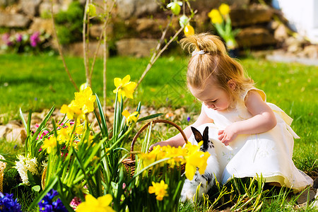 女孩在复活节用鸡蛋打彩蛋 复活节兔子 春天 草地 黄色的图片