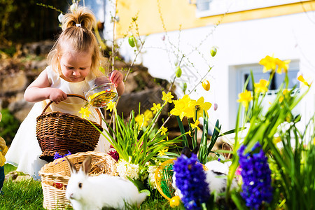 女孩在复活节用鸡蛋打彩蛋 孩子 复活节篮子 传统 兔子图片