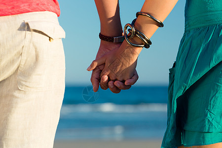男人和女人在海滩上享受日落 手牵手 自由 英俊的幸福 爱图片