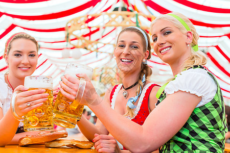 在Oktoberfest喝巴伐利亚啤酒的朋友 衣服 乐趣图片