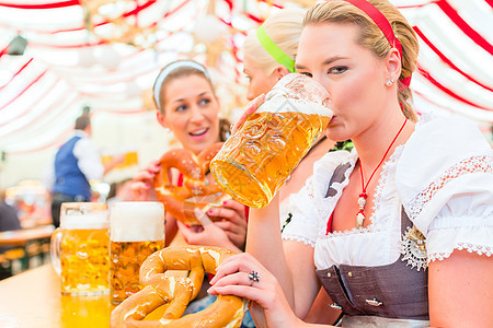 在Oktoberfest喝巴伐利亚啤酒的朋友 美丽的 坐着图片