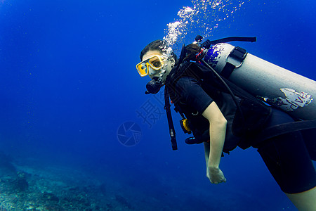 下降到礁石水肺潜水的女旅游潜水员图片