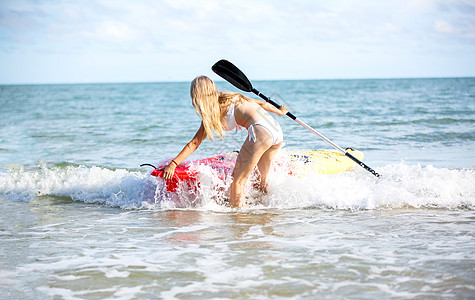 站起来桨板上的女人 在温暖的夏日海滩度假期间玩得开心 活跃的女人 比基尼 游客图片