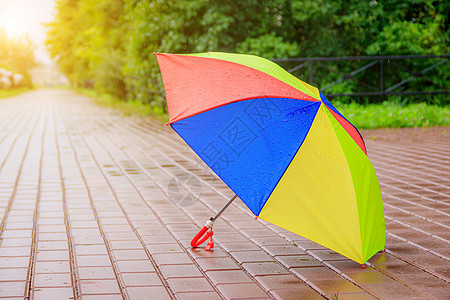 一把敞开的彩色雨伞矗立在柏油路上 夏天的雨 关于选择雨伞的文章 儿童亮伞  复制空格图片