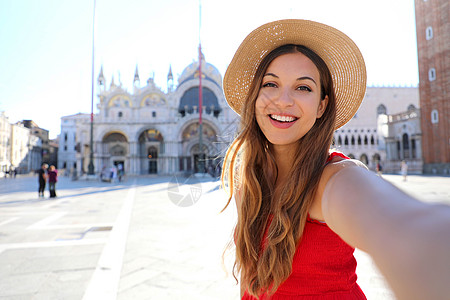暑假的威尼斯旅游女孩在圣马可广场与著名的威尼斯大教堂合影留念 意大利的欧洲旅游胜地图片